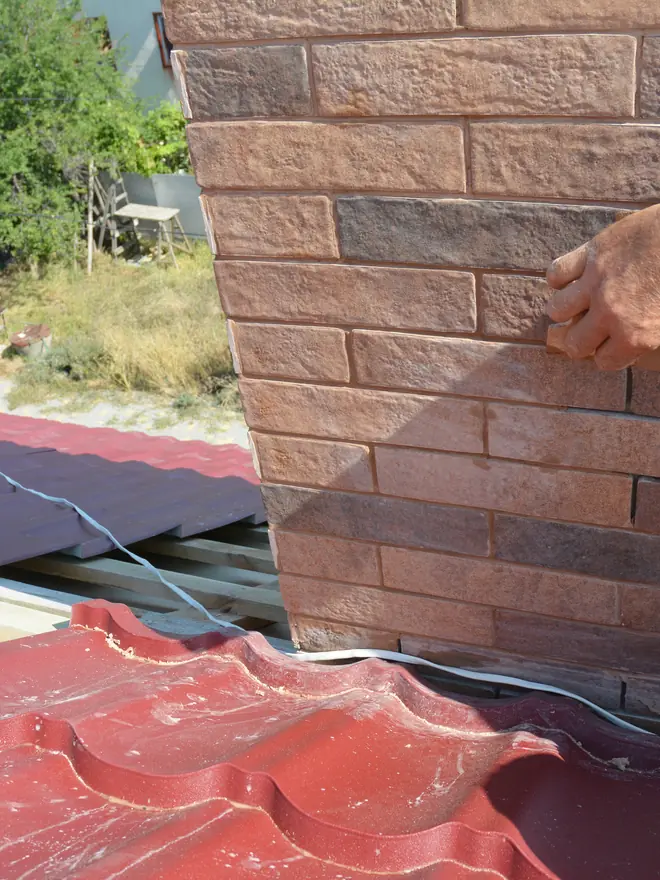 Chimney stack being repointed with a trowel