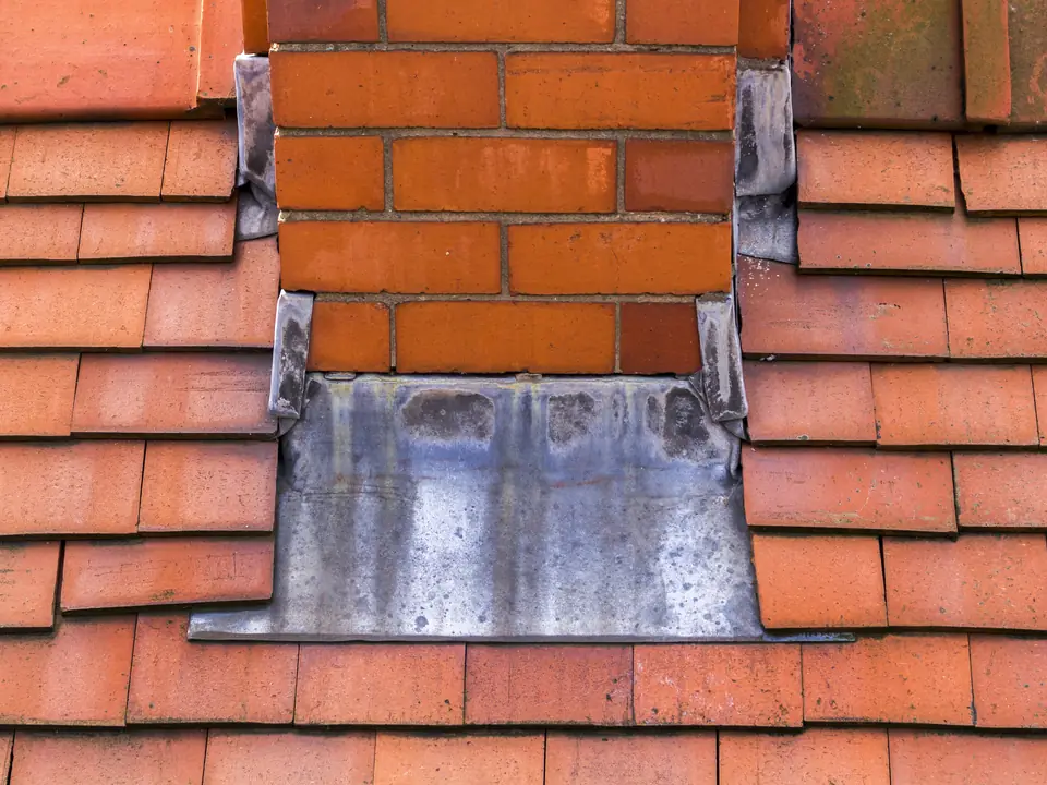 Lead apron flashing at the base of a chimney
